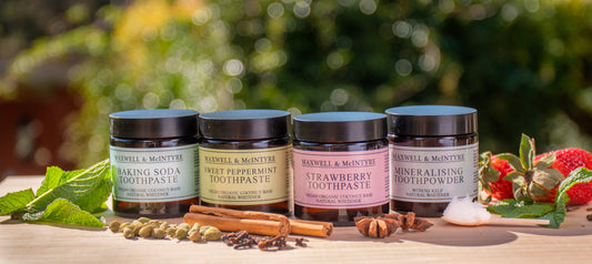 The Maxwell & McIntyre fluoride-free toothpaste and tooth powder range outdoors in a garden